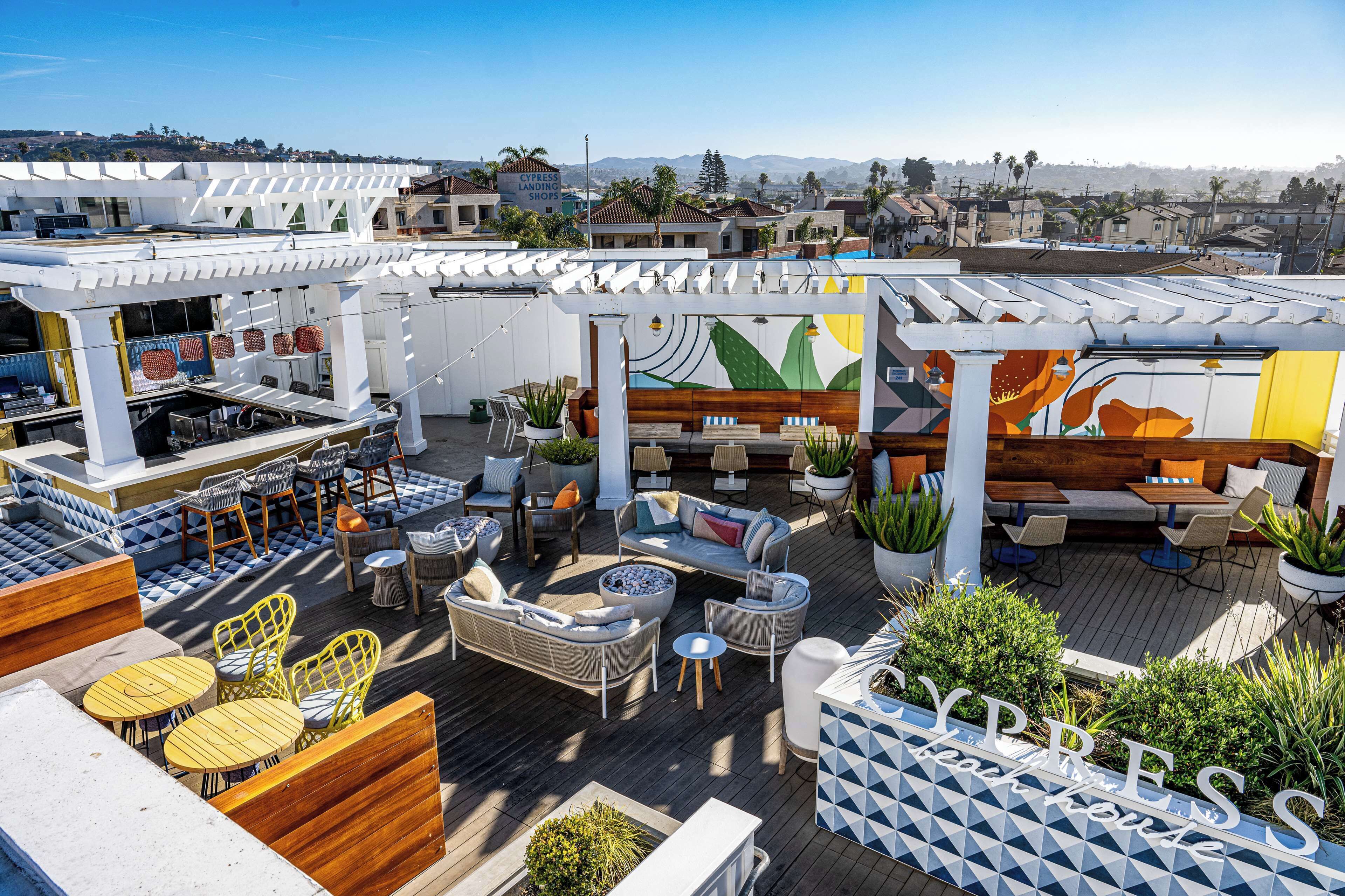 Une terrasse sur le toit avec des espaces de détente en plein air, une piscine et une vue sur le paysage urbain.