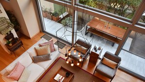 A modern living room with a sofa, chairs, a coffee table, and a dining area with a table and chairs. - Villa Amaryllis (Athens)