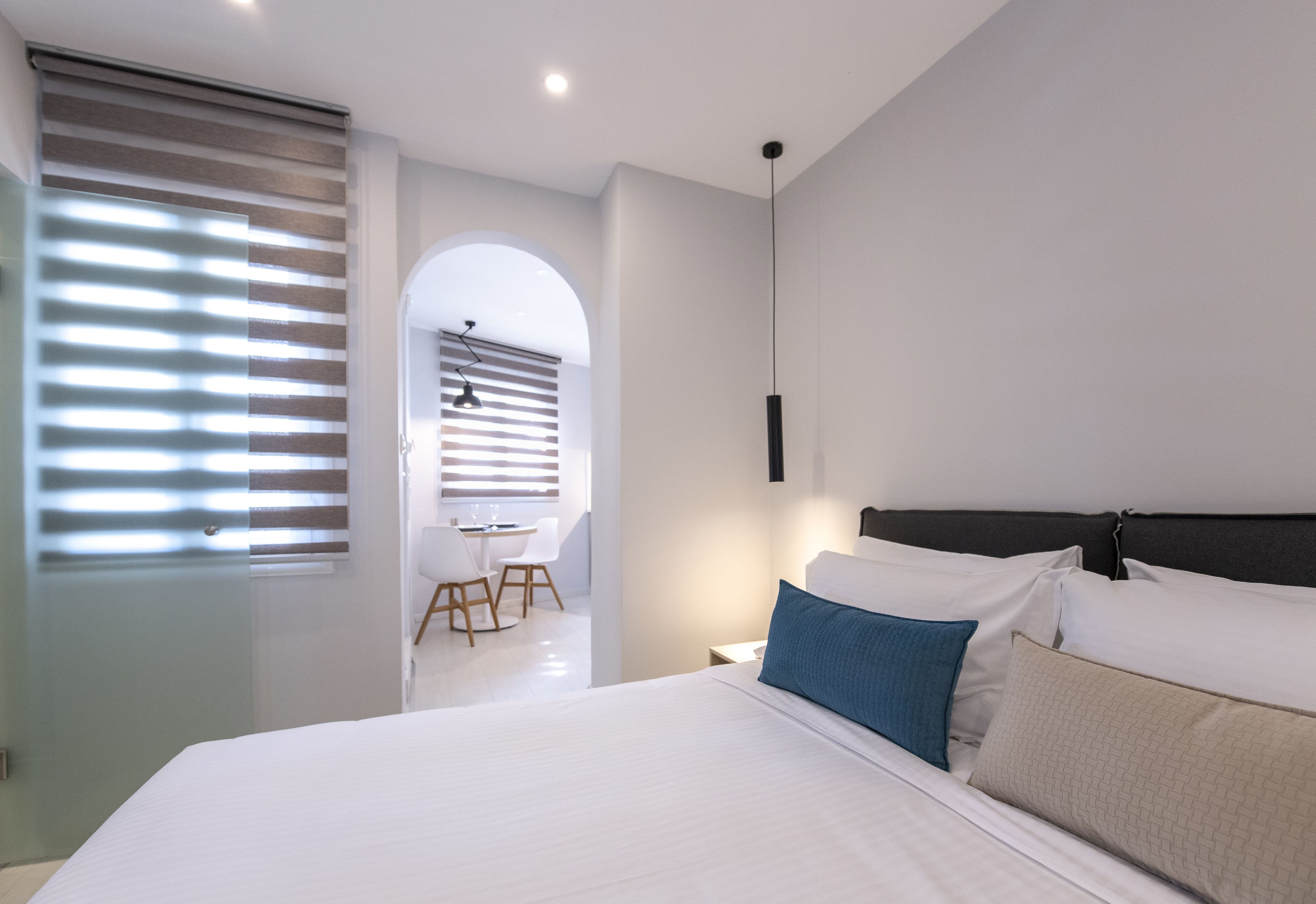 Une chambre d’hôtel moderne, dotée d’un grand lit, d’un bureau et d’une chaise.