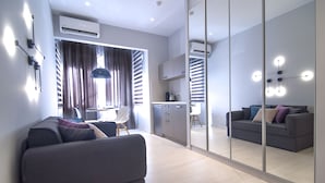 A modern living room with a sofa, a dining area, and a kitchen. - Acropolis Stay (Athens)