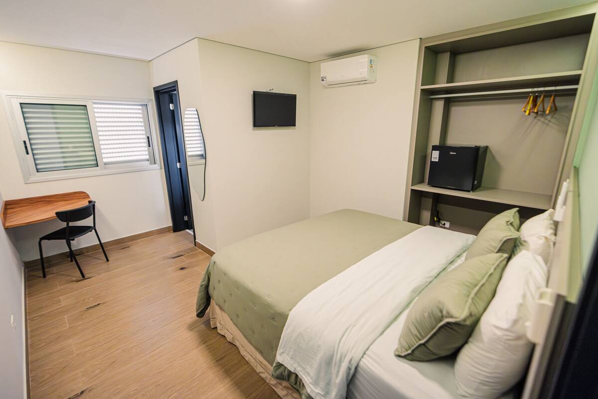 Une petite pièce propre, avec un lit, un bureau et une armoire.