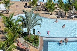 A pool area with lounge chairs, palm trees, and a tiled pool. - Reserva Caldas Lacqua 2 (Caldas Novas)