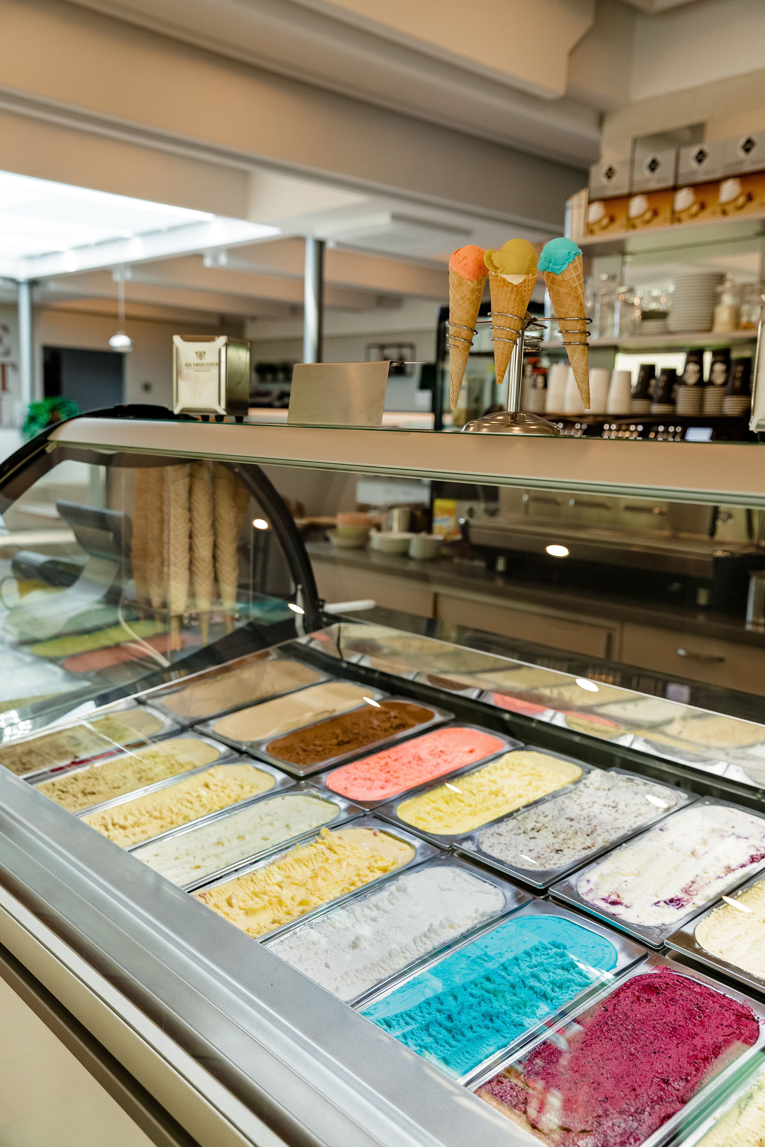 An ice cream parlor with multiple ice cream flavors in a glass display case.