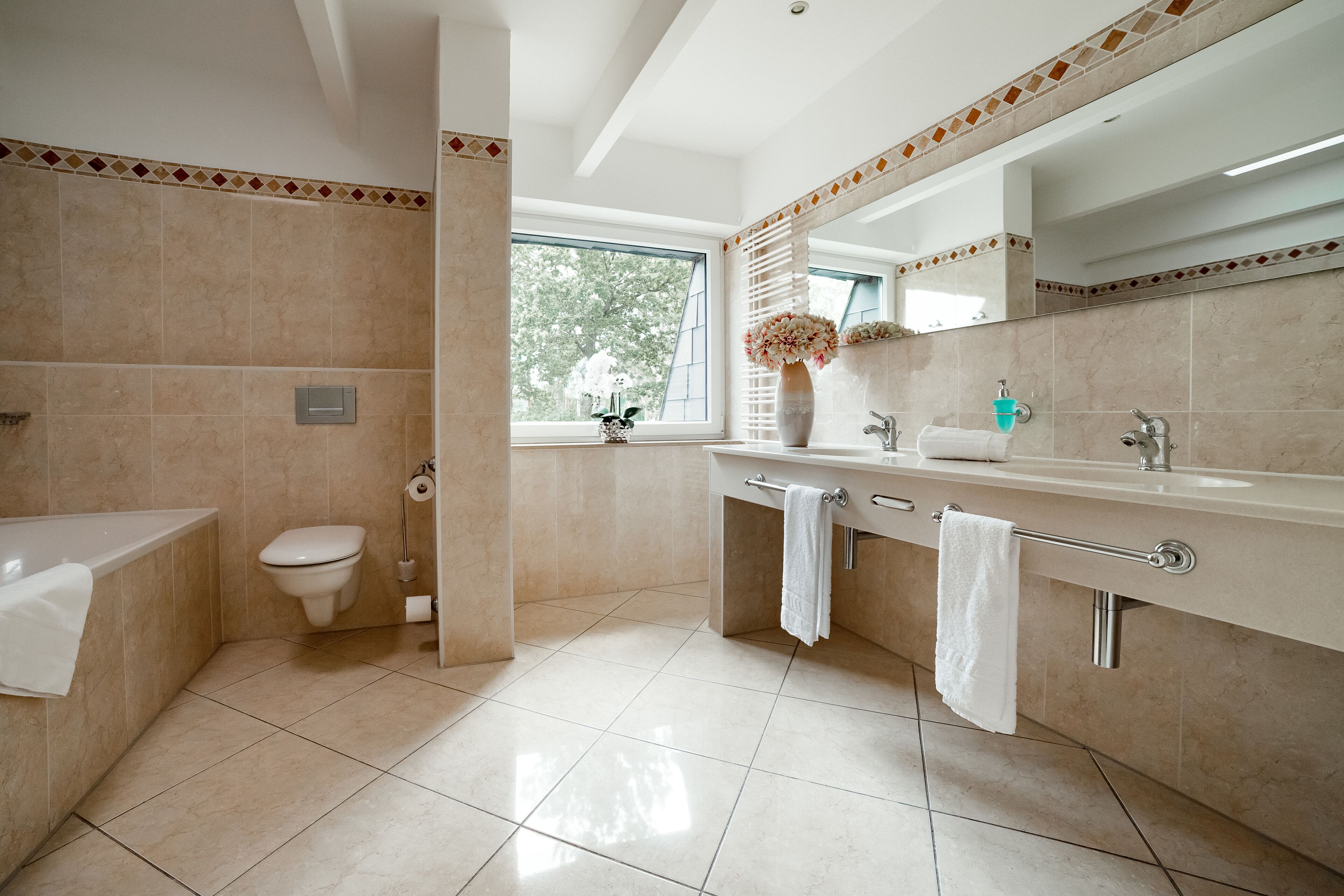 Un baño moderno con bañera, inodoro y tocador.