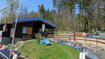 Un parque de atracciones al aire libre con una estructura de madera que dice 'JUNELSBERG FUNPARK'.