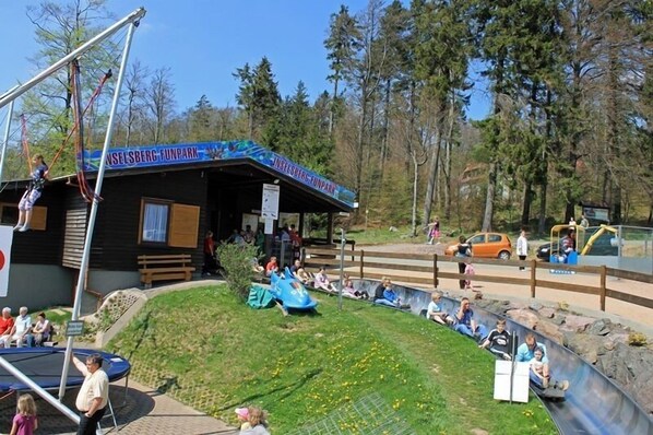 An outdoor amusement park with a wooden structure labeled "JUNELSBERG FUNPARK". - AKZENT Hotel Am Burgholz (Tabarz)