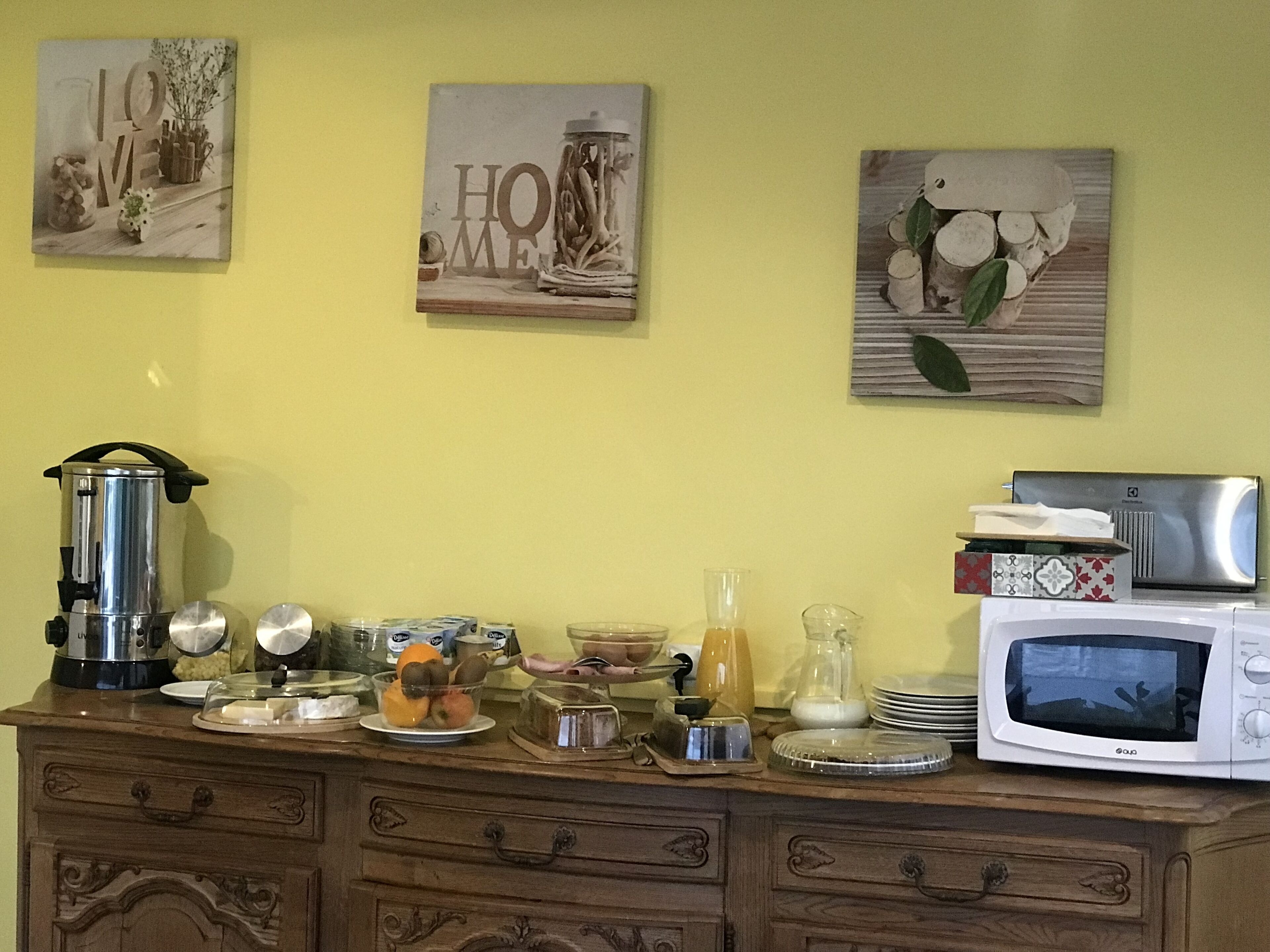 A kitchen counter with a coffee maker, toaster, microwave, and various kitchen items.