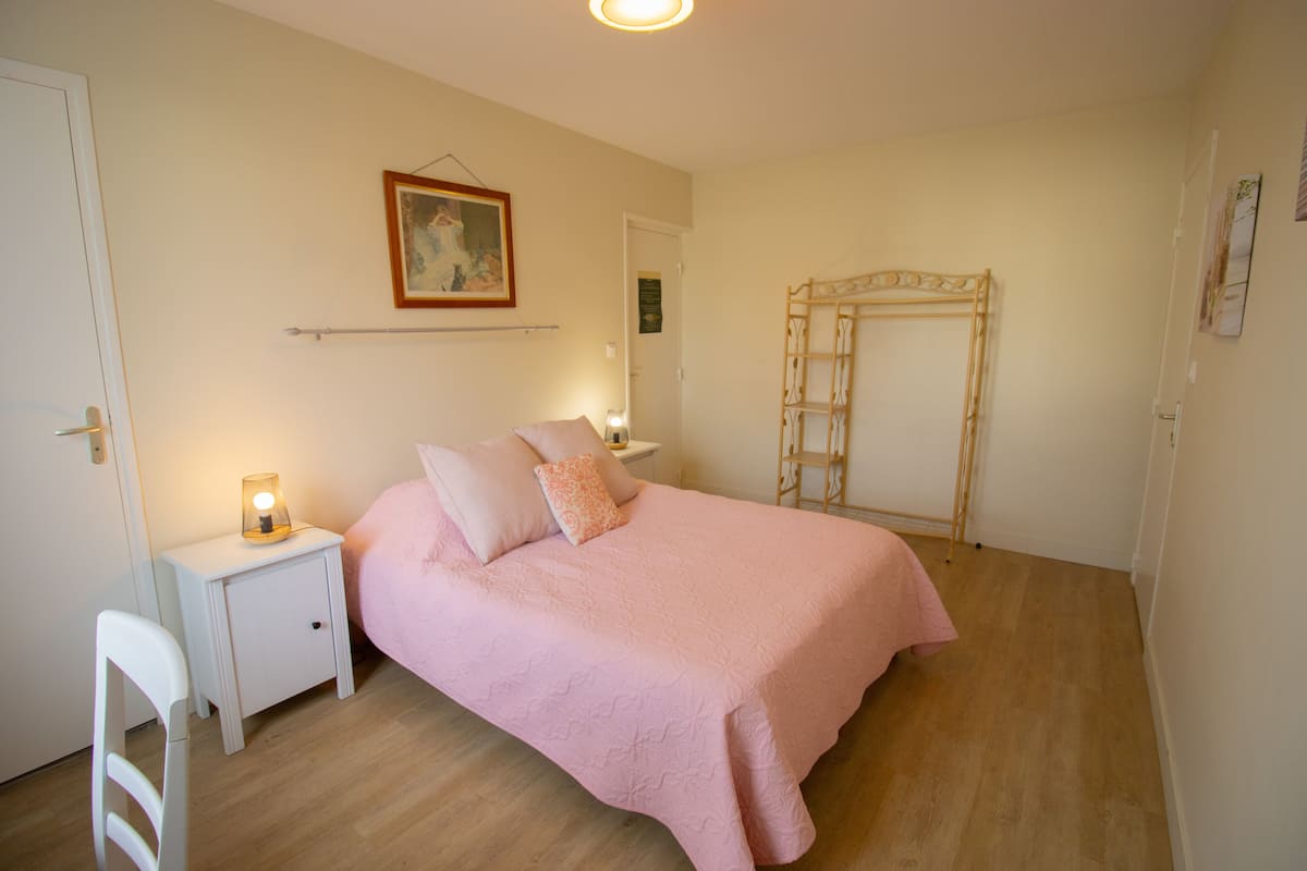Un dormitorio con cama, mesita de noche y armario.