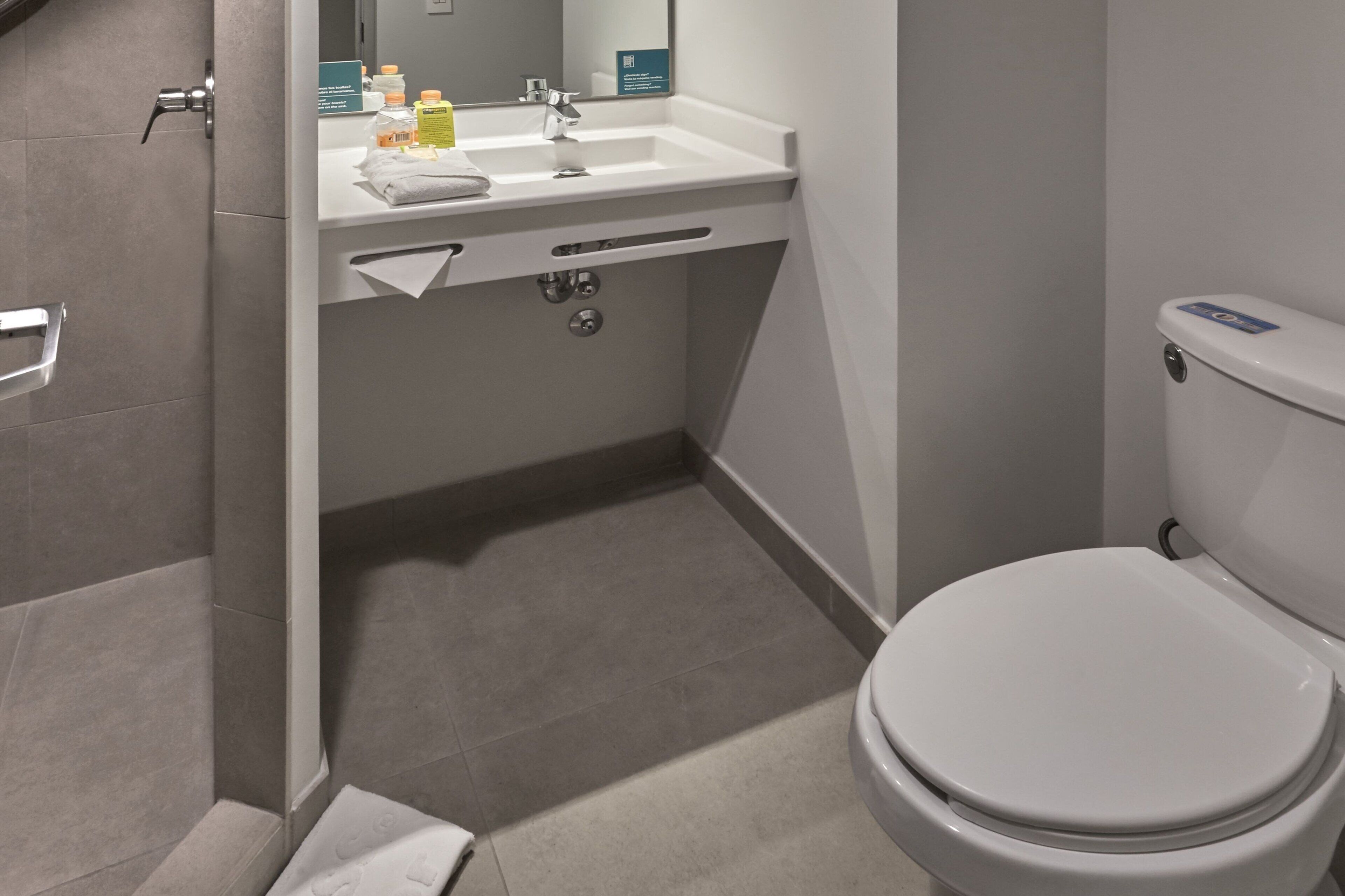 A modern bathroom with a toilet, sink, and shower.