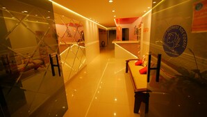 A hotel lobby with a modern design, featuring a reception desk, seating area, and glass partitions. - Pousada Recanto dos Corais (Ipojuca)