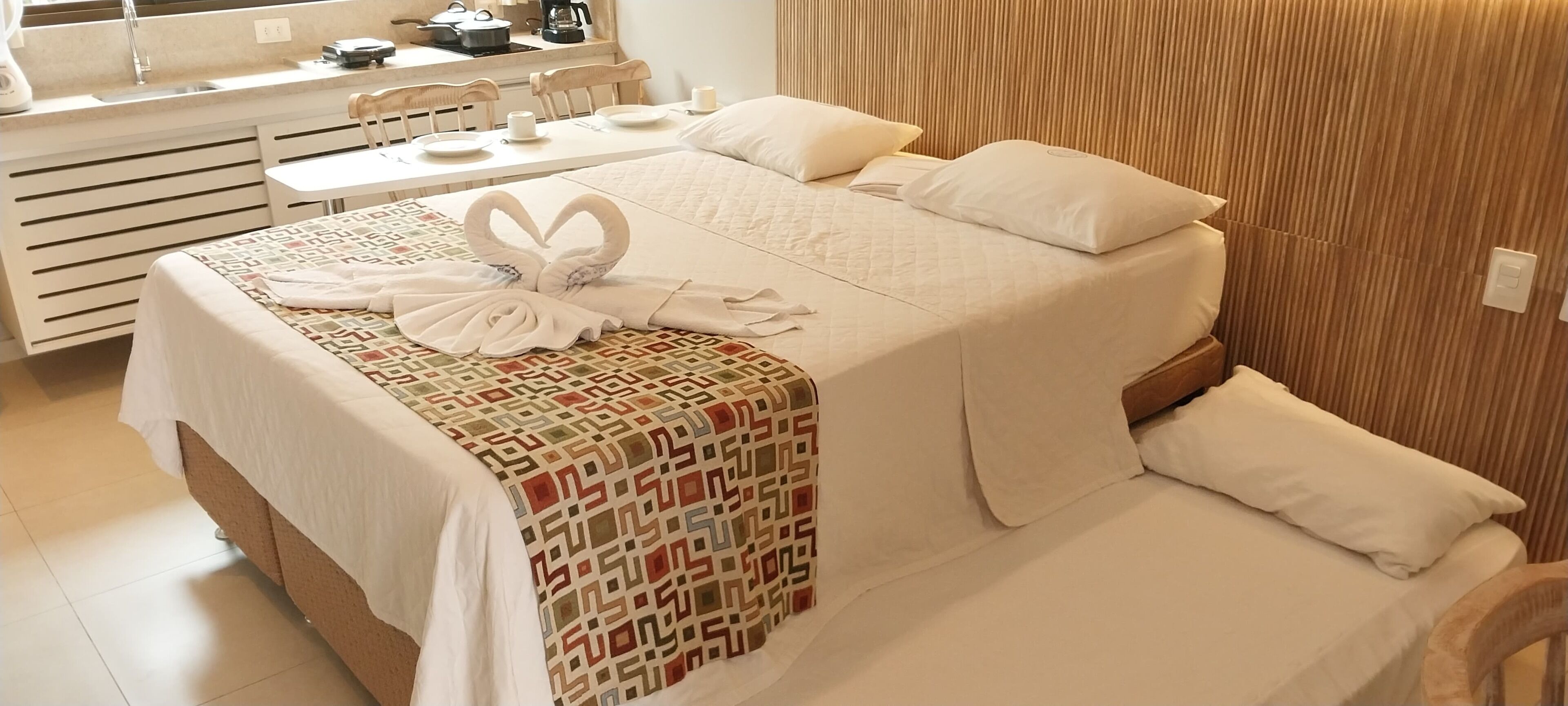 Une chambre d’hôtel avec un lit, un bureau et une kitchenette.