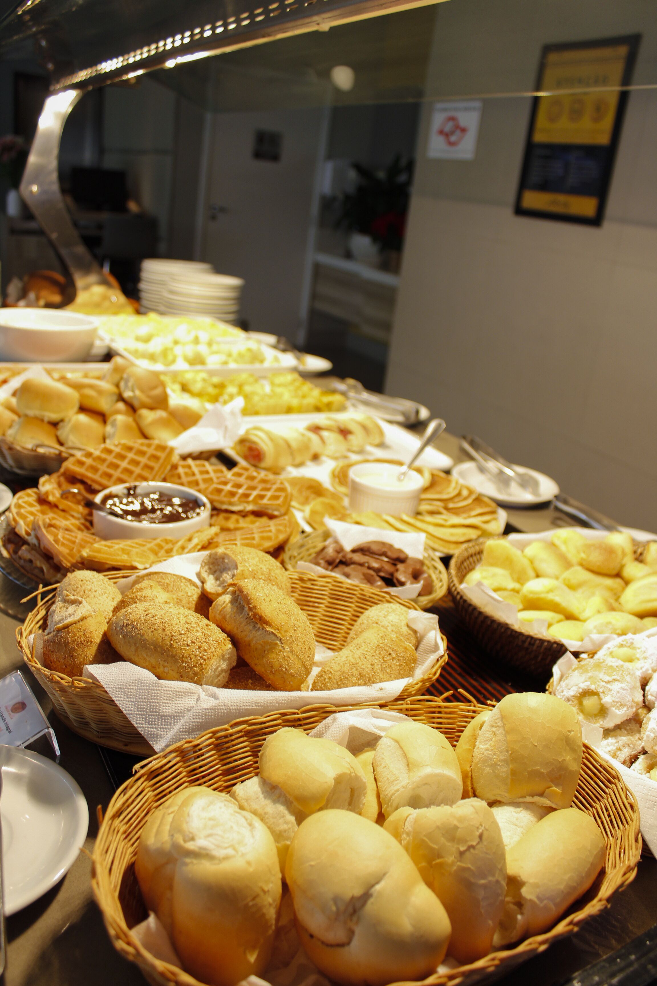 Ein reichhaltiges Buffet mit verschiedenen Speisen, darunter Brötchen, Waffeln und Gebäck.