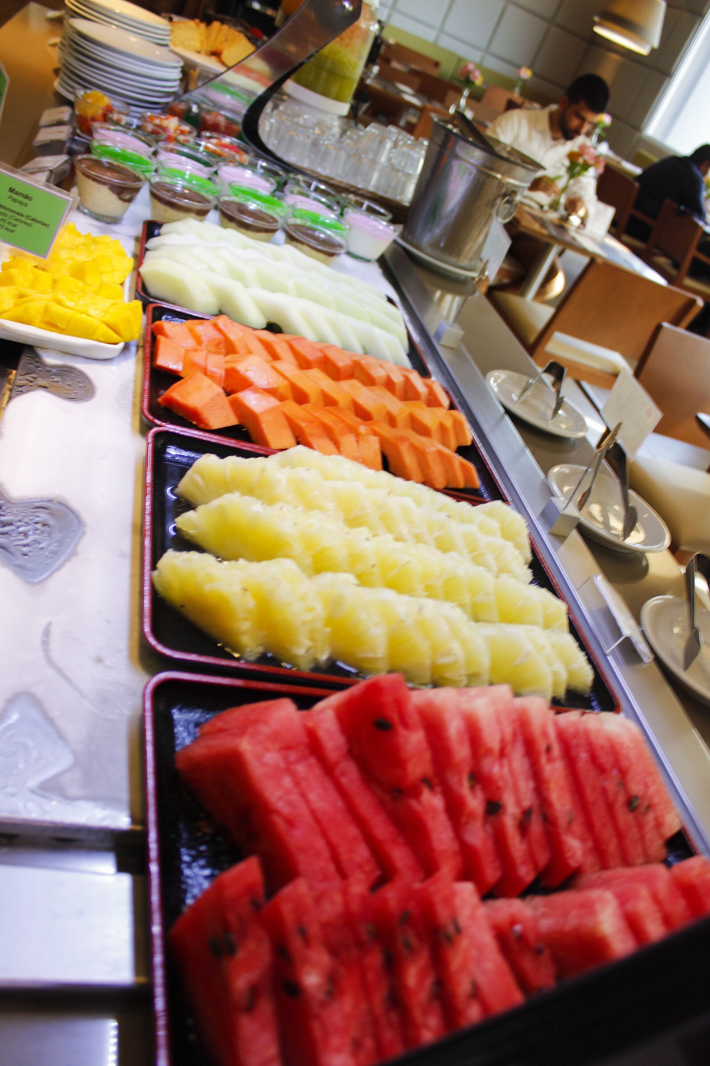 Buffet com diversas frutas e sobremesas.