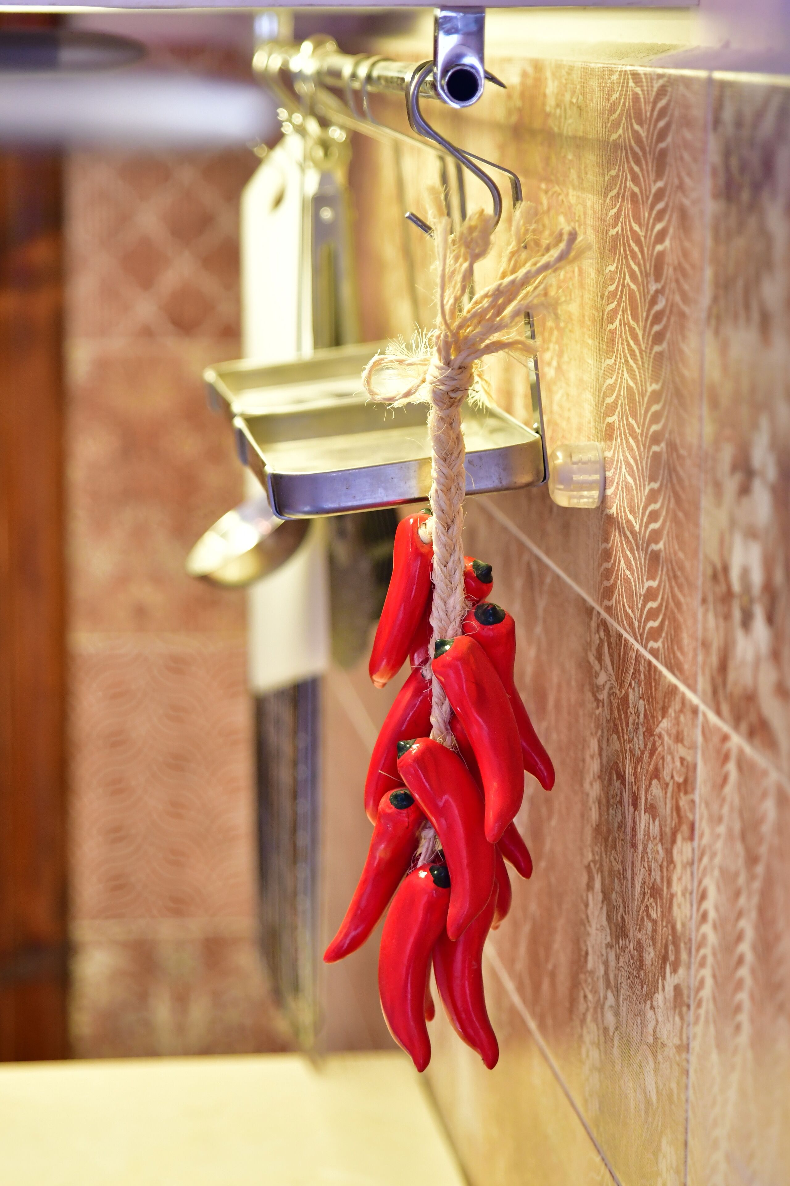 Un baño con un perchero que sostiene una cuerda y pimientos rojos.