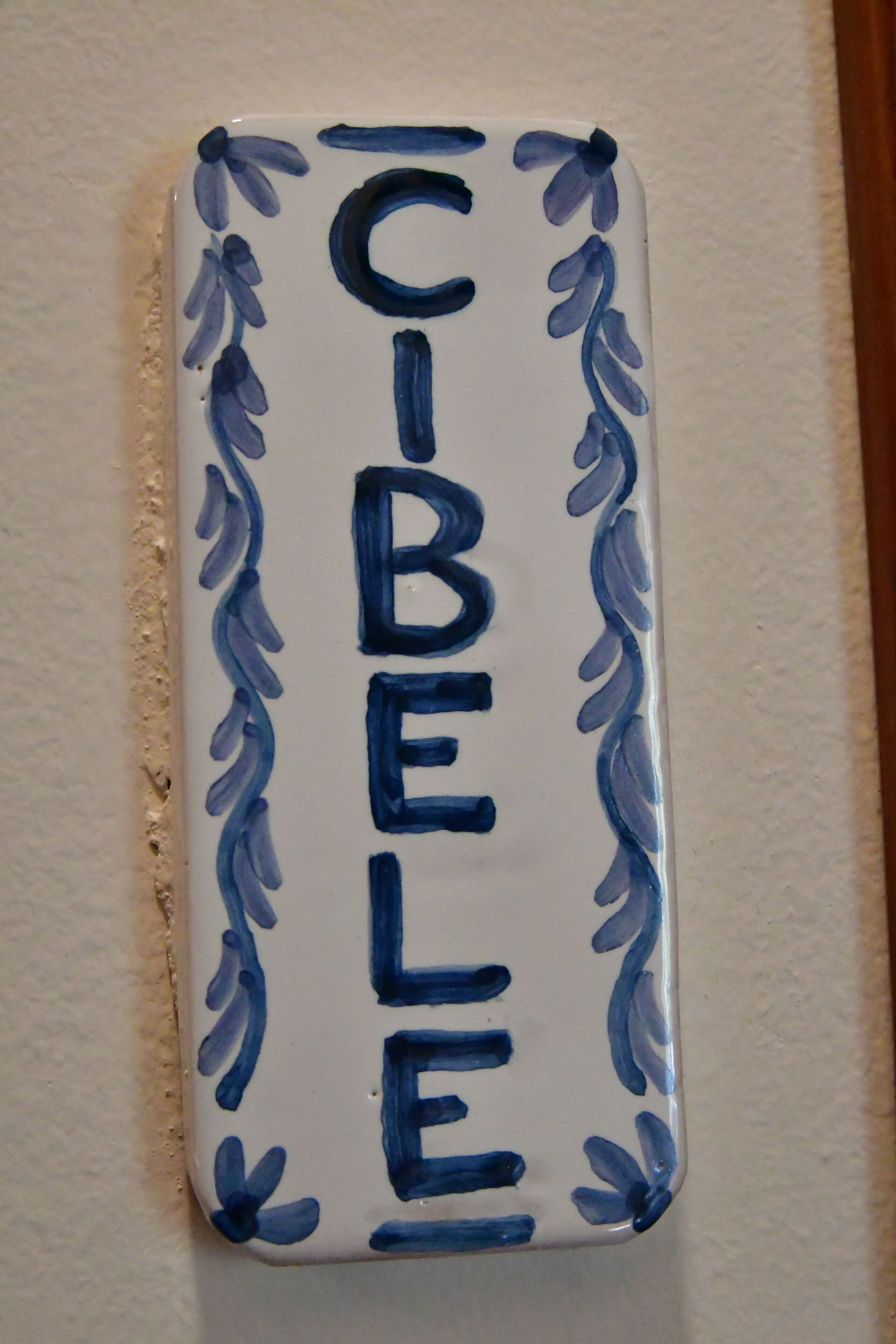 Un azulejo rectangular de cerámica con la palabra 'C-BEJE' escrita verticalmente en azul.
