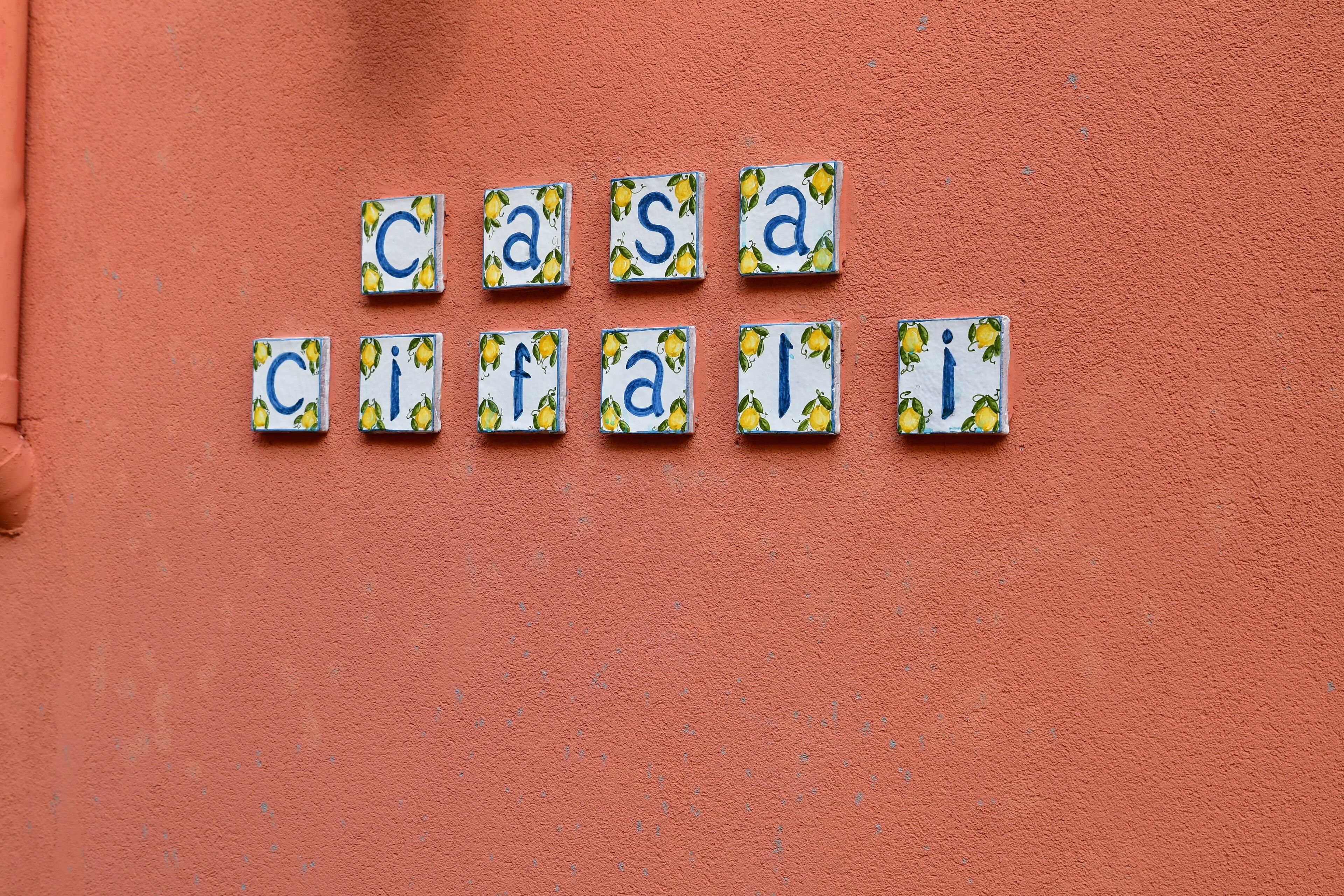 Un muro rivestito di piastrelle con le scritte 'casa' e 'cifal'.