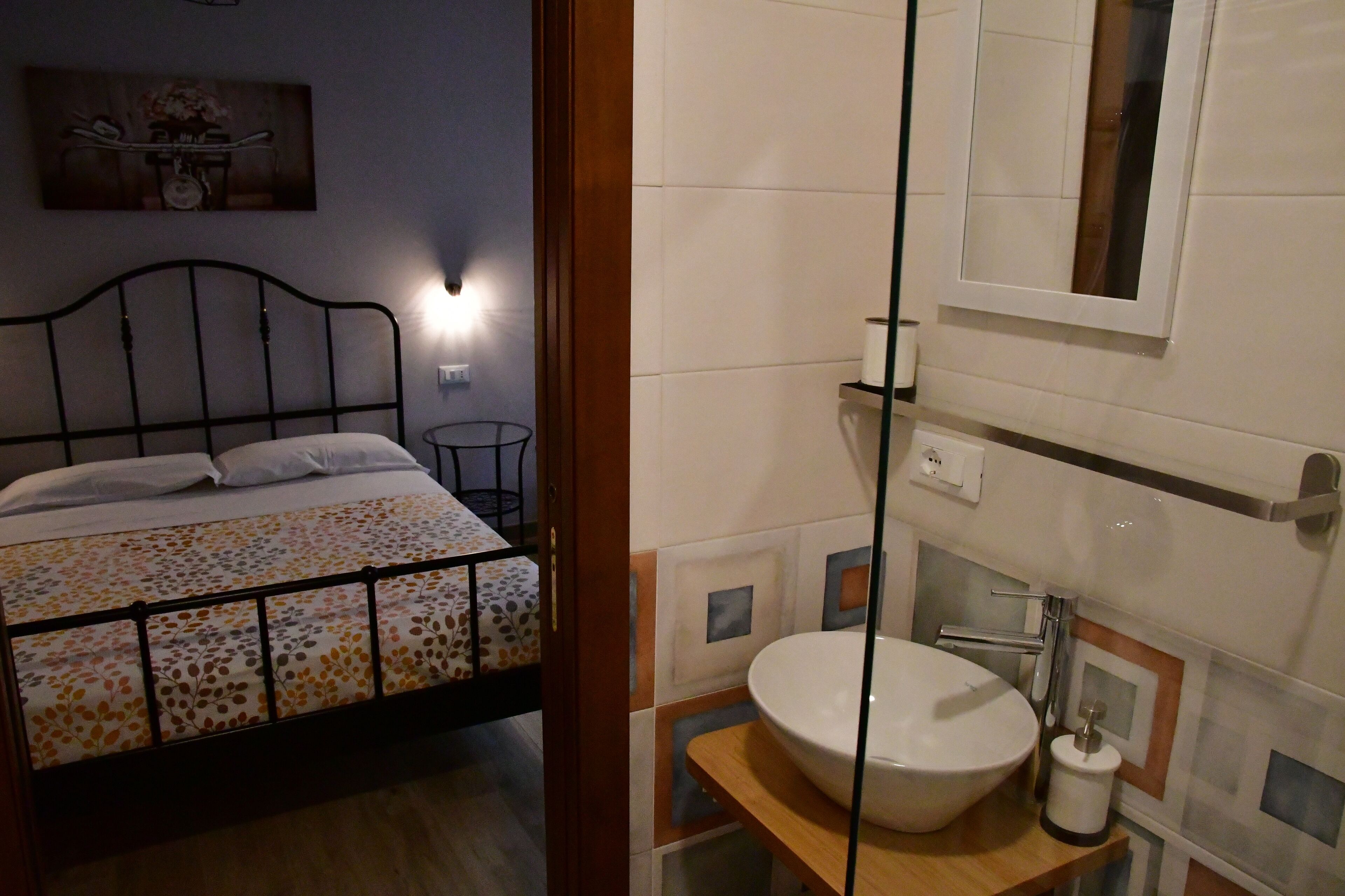 Une chambre à coucher avec un lit, une table de chevet et une lampe fixée au mur.