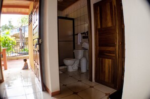 A bathroom with a toilet, a sink, and a shower area. - Hotel y Restaurante Las Tablitas (Monterrey)