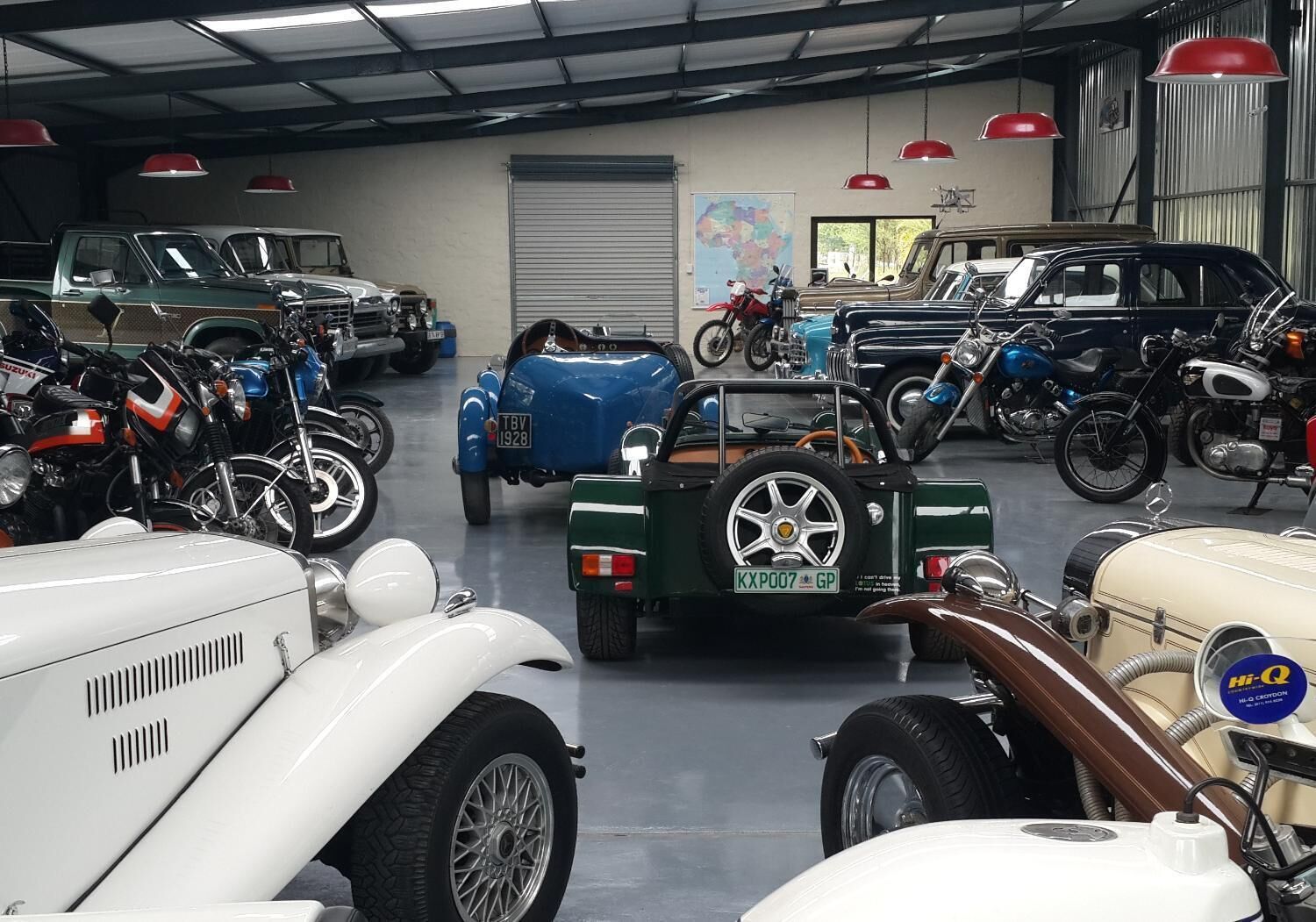 A vintage car show with various classic cars and motorcycles on display.