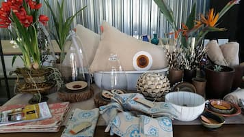 Une variété d’objets décoratifs, notamment des plantes, des vases et des textiles, sont disposés sur une table.