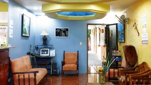 A living room with a skylight, a television, a computer, and a dining area with chairs and a table. - Hotel Río Tempisque (Nicoya)