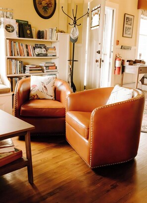 Relax in a cozy living room with a comfortable seating area, featuring a wooden table and chair.