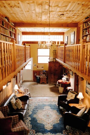 Cozy interior with a fireplace, dining table, and bookshelves.