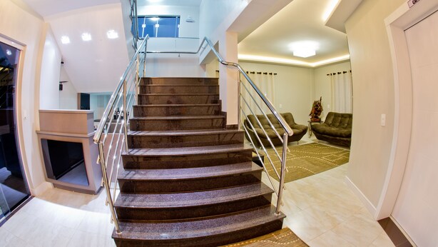 A modern staircase with a glass railing leading to an upper floor. - North Hotel (Chapecó)