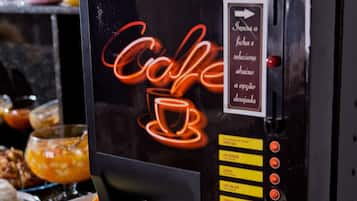Eine Kaffeemaschine mit einer Neonreklame, einer Tasse und einer Portion Pommes.
