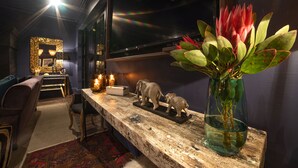 A modern living room with a wooden coffee table, a sofa, and a decorative elephant sculpture. - La Fontaine (Franschhoek)