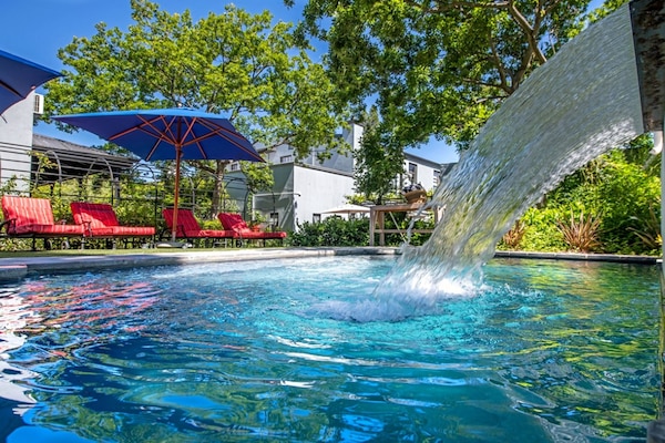 Een buitenzwembad en ligstoelen