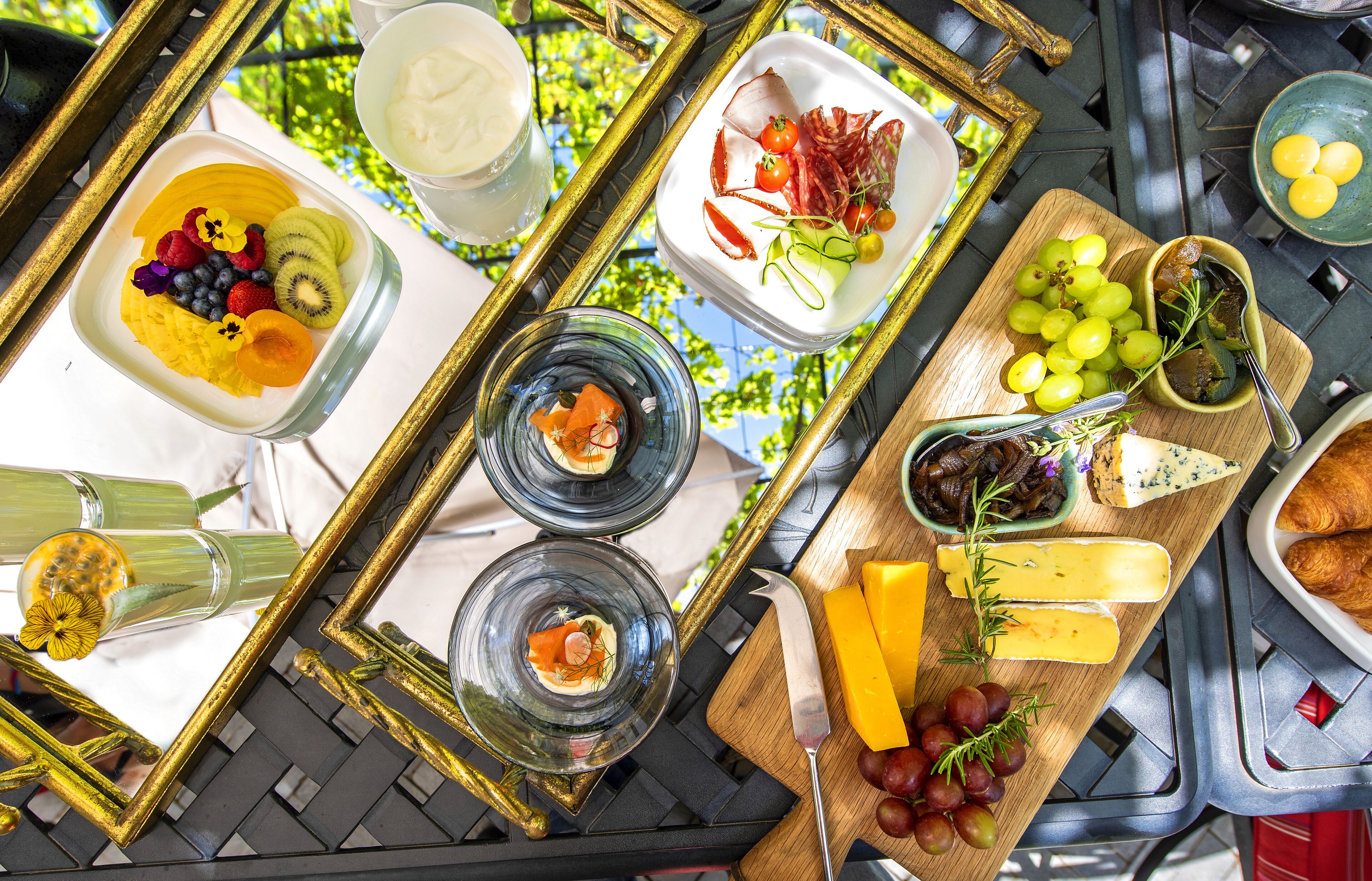 A table with various food items, including fruits, cheese, and bread, arranged on a tray.