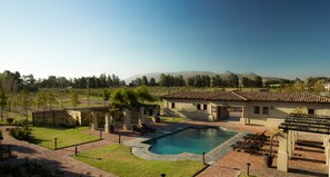 Una piscina al aire libre, sillones reclinables de piscina