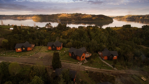 A lakeside property with several cabins, a dock, and a forested landscape.