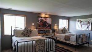Une chambre avec deux lits, une grande fenêtre et une décoration murale sur le thème des chevaux.
