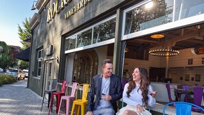 A couple seated outside a building with a sign reading "ROCK VINEYARDS". - Rockhouse Suites (Healdsburg)