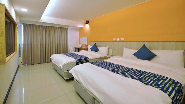 A hotel room with two beds, a desk, and a chair. - Good Night Hotel (Taoyuan City)