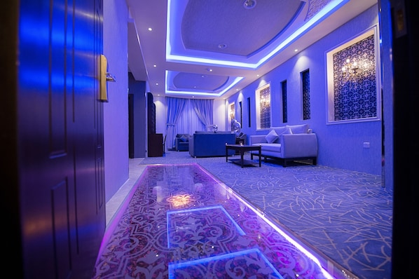 A hotel lobby with a patterned carpet, a reception desk, and a sofa. - Rest Night Serviced Apartments Wadi Al Dawasir رست نايت للشقق المخدومة - وادى الدواسر (Wadi-Ad-Dawasir)