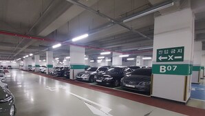 Un aparcamiento de varios niveles con plazas delimitadas y señales de dirección claras.