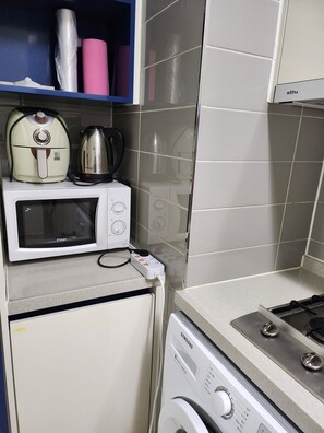 Una cocina compacta con microondas, hervidor y lavavajillas Samsung.