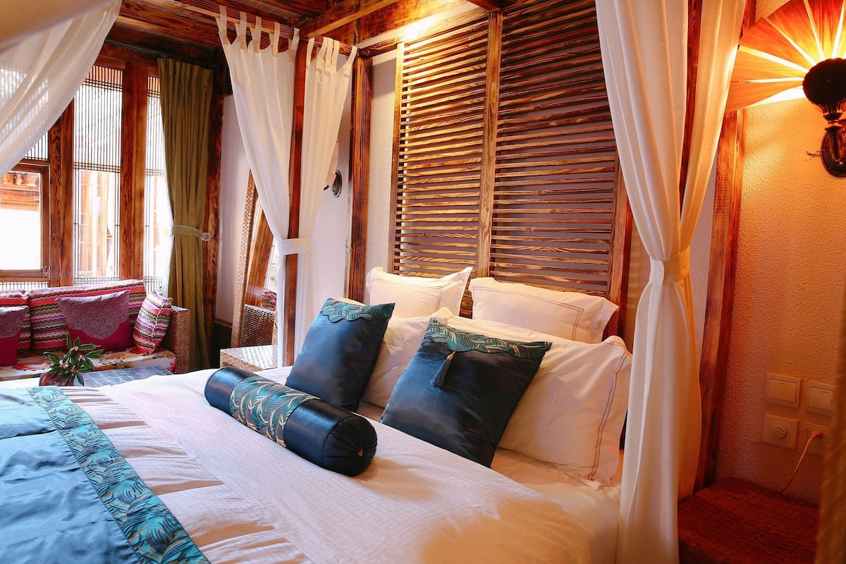 A well-appointed bedroom with a large bed, multiple pillows, and a canopy.