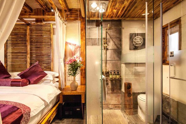 A bedroom with a bed, a nightstand, a glass-enclosed shower, and a wooden ceiling. - Lijiang Spiritual Utopia Hotel (Lijiang)