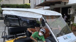 A yellow golf cart with a white canopy, parked on a street. - Krit Place (Nonthaburi)