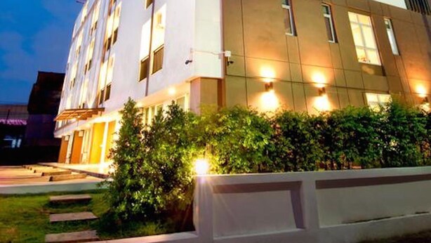 A modern hotel with multiple floors, large windows, and a well-lit facade. - Krit Place (Nonthaburi)