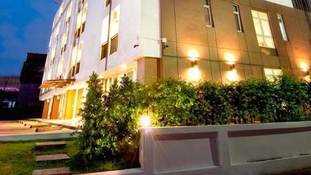 Ein modernes Hotel mit heller Fassade, zahlreichen Fenstern und einer flachen Dachkonstruktion.