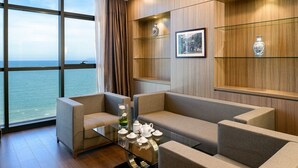 A modern living room with a glass coffee table, beige sofas, and a view of the sea through large windows. - The Nalod Da Nang (Da Nang)