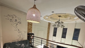 A modern living room with a sofa set, a map on the wall, and a ceiling fan. - Alleyway Hostel - Adults Only (Ho Chi Minh City)