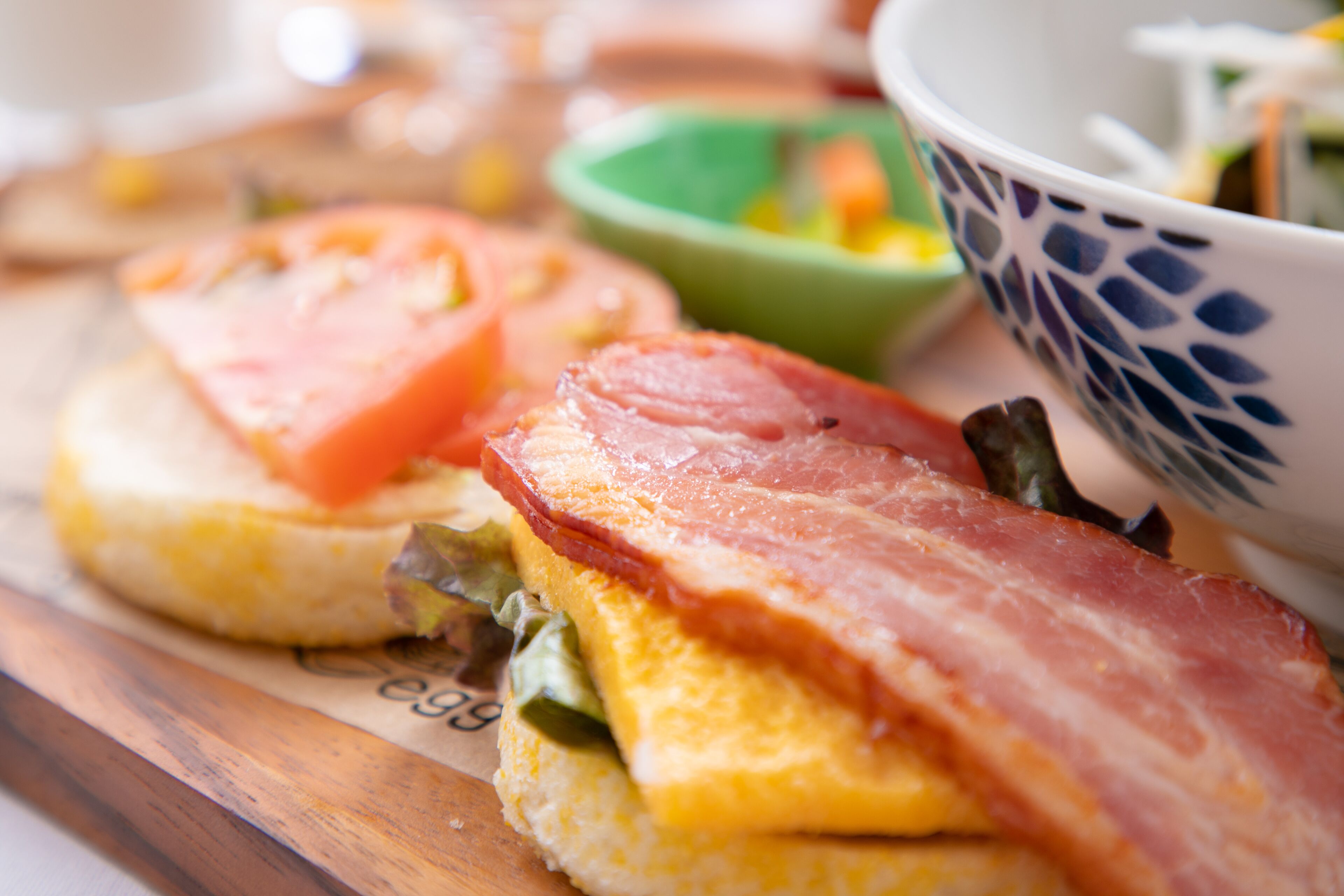 Un plato de desayuno con huevos, tocino y tomates.