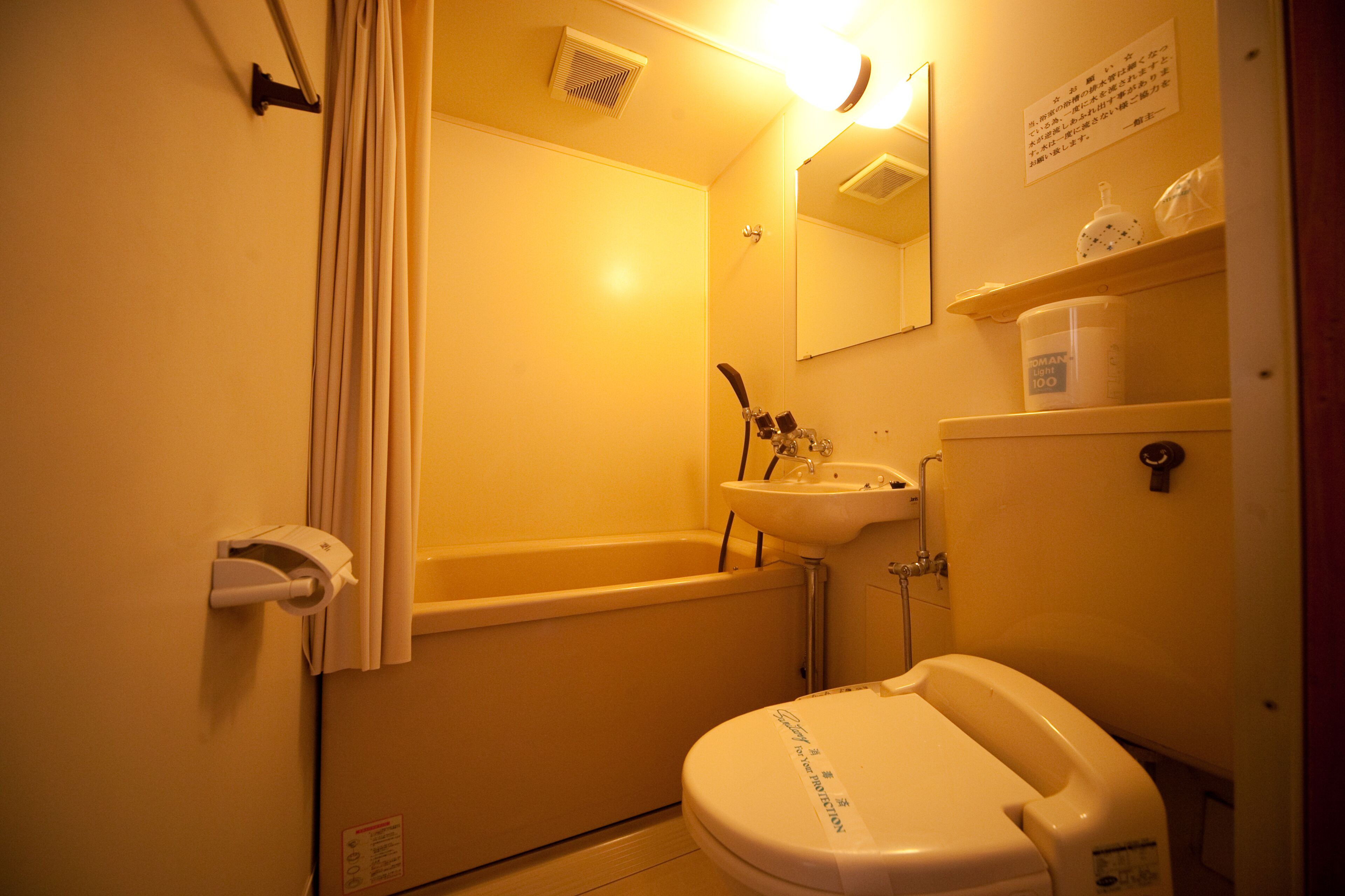 A small, compact bathroom with a bathtub, sink, and toilet.