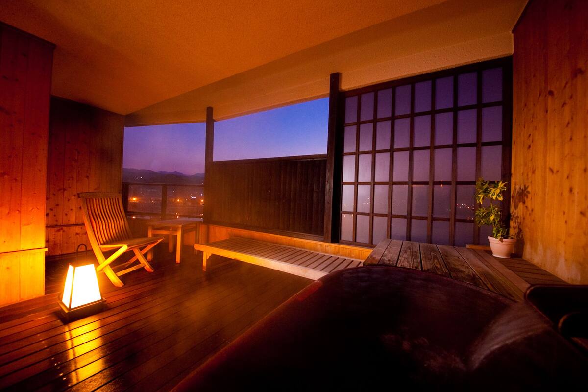 A wooden deck with a sofa, a chair, and a table.